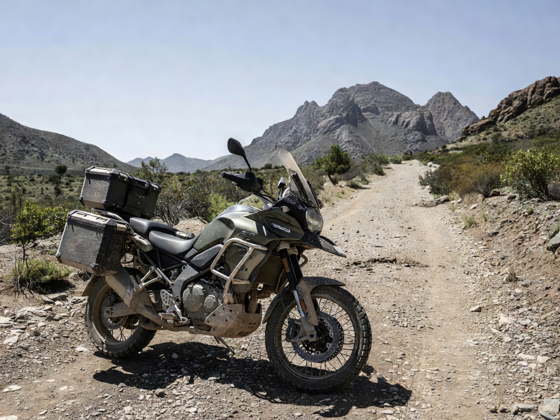 Rugged adventure touring motorcycle with panniers on an unpaved gravel trail